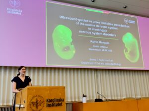 Katrin Mangold standing next to her PhD thesis presentation.